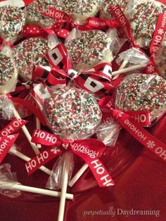 many lollipops are wrapped in red and white paper with christmas decorations on them