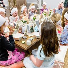 a group of children sitting around a table with pictures on it and candles in front of them