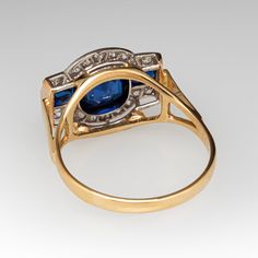 This stunning circa 1930s antique ring features a semi-bezel set, round cut center sapphire, two baguette cut side sapphires, and 18 bead set, round single cut accent diamonds. The ring measures 11.4mm at the top, rises 5.5mm above the finger, tapering to 2.0mm wide and 0.8mm thick at the base of the shank. The ring is currently a size 7. The sapphires show gentle abrasion and the ring overall is in great shape. Art Deco Ring With Bezel Setting, Classic Multi-stone Sapphire Ring With Baguette Cut, Art Deco Yellow Gold Diamond Ring With Bezel Setting, Art Deco Sapphire Ring With Baguette Cut, Art Deco Sapphire Baguette Cut Ring, Vintage Multi-stone Oval Sapphire Ring, Vintage 14k Gold Sapphire Ring With Bezel Setting, Vintage Blue Sapphire Ring With Bezel Setting, Vintage Oval Multi-stone Sapphire Ring