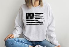 "Fishing T-shirt with American Flag Sweatshirt, Patriotic Sweatshirt, American Flag Fishing Sweatshirt, Fisherman Gift, Fishing Lover Shirt Show your patriotic fishing spirit with this American Flag Fishing Sweatshirt! Perfect for fishermen and patriotic individuals. Get yours now and reel in the style! Hi! Welcome to✨Northstar Sweatshirt &Hoodies✨ ✨As the weather gets colder, you want clothes that keep you and your body warm. Here, Northstar Sweatshirt &Hoodies is ready to keep you warm with it Casual Crew Neck Fishing T-shirt, Casual Crew Neck T-shirt For Fishing, Casual Crew Neck Top For Fishing, American Flag Sweatshirt, Fishing Sweatshirts, Fisherman Gifts, Body Warmer, Fishing T Shirts, American Flag