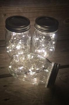 three mason jars with fairy lights in them