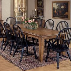 a dining room table surrounded by chairs and an area rug