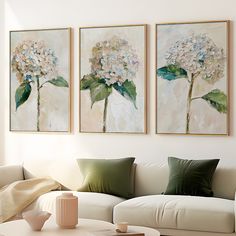 two paintings on the wall above a couch in a living room with white furniture and green pillows