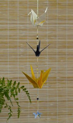 an origami bird mobile hanging from a string with two birds on each side