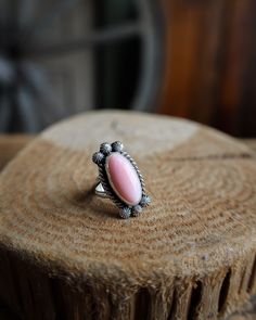 Pink Conch Slim Oval Ring- Size 7.5 Native American Material: Sterling Silver and Pink Conch Measurement: 1" (L) x .5" (W) Size: 7.5 Oval Opal Promise Ring, Sterling Silver Ring With Large Oval Stone, Oval Sterling Silver Ring With Large Stone, Oval Sterling Silver Rings With Large Stone, Heirloom Style Oval Opal Ring, Handmade Oval Heirloom Jewelry, Handmade Heirloom Oval Jewelry, Vintage Oval Rings With Large Stone, Classic Oval Cabochon Opal Ring