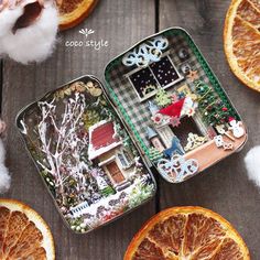 an open tin box with orange slices on the table next to cotton balls and other decorations