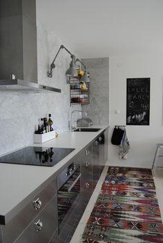 a modern kitchen with stainless steel appliances and rug