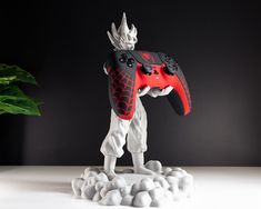 an action figure holding a video game controller in its hand and standing on some rocks