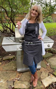 a woman standing in front of an outdoor grill