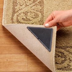 a person is placing a rug on the floor with a triangle shaped piece of carpet