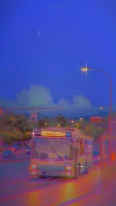 a blurry photo of a bus driving down the street at night time with lights on