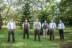 a group of men standing next to each other on top of a lush green field