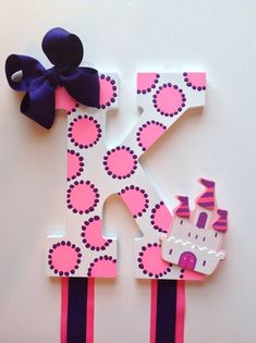 the letter k is made out of paper and has a purple bow on its head