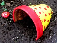 a red and yellow plastic cone sitting on top of dirt