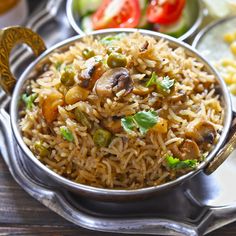 a silver bowl filled with rice and vegetables