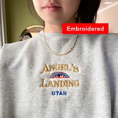 "\"Angel's Landing Utah\" embroidered on a comfy vintage-style crewneck. If you're on the lookout for both style and comfort, this fleece sweatshirt is the perfect choice. And with up to 5% recycled polyester in components, you'll be taking a little step closer to a more earth-friendly way of life. *Sizes Are Unisex * 50% cotton, 50% polyester (up to 5% recycled polyester, made from plastic bottles) * Fabric weight: 7.8 oz/y² (264.5 g/m²) * Patented low-pill, high-stitch density PrintPro® XP fle Vintage Embroidery Sweatshirt, Vintage Embroidered Sweatshirt, Vintage Tshirt Design, Crewneck Embroidery, National Park Gifts, Angels Landing, Embroidery Sweatshirt, Vintage Graphic Design