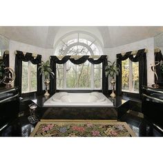 a large bathroom with black and white decor on the walls, windows, and rugs