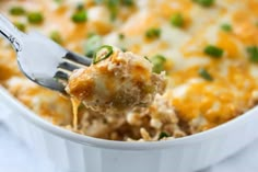 a close up of a spoon with food in it and green onions on the side