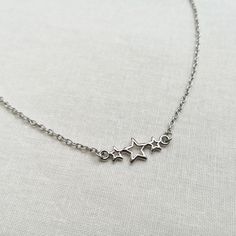 "A beautiful celestial necklace. This necklace has a rhodium colour plated charm with three stars on rhodium colour plated chain (the colour is not bright, unlike silver plated equivalents). This lovely necklace is perfect as a gift or treating yourself. Great for layering or can be worn on its own. Necklace lengths: - 14\" (adjustable to 16 3/4\" with 2 3/4\" extension chain) - 16\" (adjustable to 18 3/4\" with 2 3/4\" extension chain) - if you would prefer a different length, please leave a note at check out  The necklace is made to order and will be ready to ship within 3 days. Packaging: Please choose your packaging type from the drop down menu.                   - Pink necklace card and organza bag (as shown in the listing photo)                    - White gift box (gift wrapped with Celestial Silver Necklace Nickel Free, Silver Celestial Charm Necklace With Adjustable Chain, Silver Celestial Necklace With Star Charm, Celestial Silver Necklace With Star Charm, Silver Celestial Nickel-free Charm Necklaces, Silver Star-shaped Jewelry With Delicate Chain, Sterling Silver Necklace With Delicate Star Chain, Celestial Silver Charm Necklaces With Delicate Chain, Silver Star Charm Necklaces