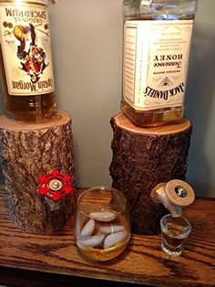 two bottles of alcohol sitting on top of wooden logs