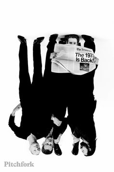 two people are upside down in the air with newspapers on their backs and feet above them