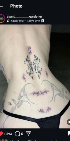 the back of a woman's stomach with tattoos on her side and an image of flowers