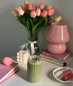 pink and yellow tulips are in a vase next to some other items on a table