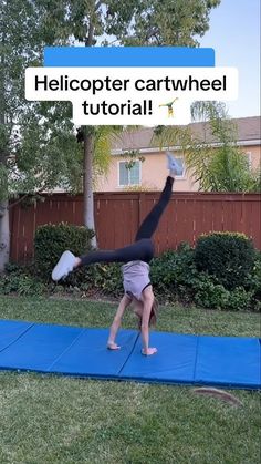 a person doing a handstand on a blue mat