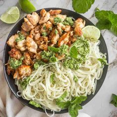 a bowl filled with noodles, chicken and broccoli on top of a table