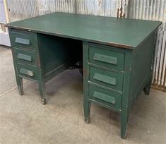 an old green desk with three drawers