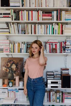 a woman standing in front of a bookshelf