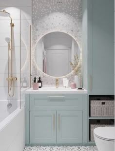 a bathroom with blue cabinets and white tile on the floor, along with a round mirror above the sink