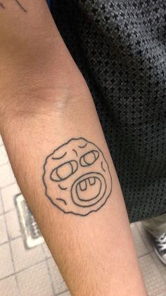 a person with a tattoo on their arm has a smiley face drawn on his arm