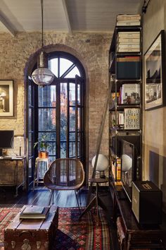 a living room filled with furniture and a large window next to a book shelf covered in books