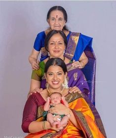 two women and a baby are posing for a photo in their mother's arms