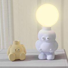 an elephant lamp next to a yellow and white one