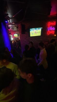 a group of people in a bar watching tv