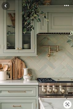 an image of a kitchen setting with green cabinets and white counter tops, including a stove