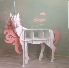 a pink and white horse shaped desk in front of a wall with the words happy birthday written on it