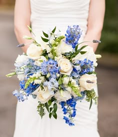 a bridal holding a bouquet of blue and white flowers