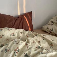 an unmade bed with two pillows and a pillow case on top of the bed