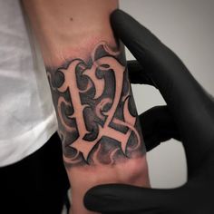 a person with a black and white tattoo on their arm holding up a small wrist