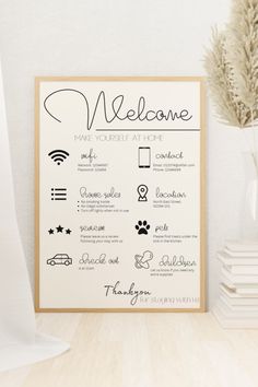 a welcome sign on a table next to a vase