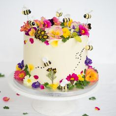 a white cake with flowers and bees on it