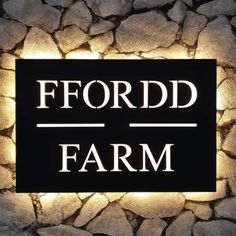 a black and white sign that reads ford farm on it's side with rocks