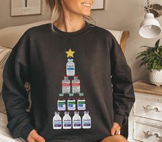 Get ready to sleigh the holiday season with this hilarious Christmas nurse sweatshirt! Instead of a traditional Christmas tree, this festive sweatshirt features a tower of medication bottles arranged in the shape of a tree. Perfect for nurses who are always on the go, this cozy sweatshirt will keep you warm and laughing all winter long. Whether you're administering medication or decking the halls, this sweatshirt is sure to inject some holiday cheer into your day. So grab a cup of eggnog (or something stronger), and let's get this party started! Our Gildan crewneck sweatshirts are an amazing, comfortable midweight sweatshirt. The perfect sweatshirt for everyday wear and nice and warm for those cold winter nights. These sweatshirts are printed with a professional DTG garment printer for a s Administering Medication, Pharm Tech, Nursing Sweatshirt, School Sweatshirts, Med Surg, Traditional Christmas Tree, Nurse Christmas, Funny Nurse, Nurse Sweatshirt