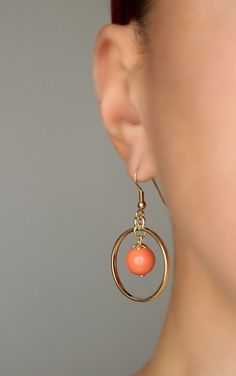 This lovely earrings was made of peach coral color glass 10 mm beads, gold plated brass bead caps, gold tone open circle charms and gold plated brass base earrings hooks. Earring hooks are from nickel free and lead free metal. *The total lenght of earrings is about 45 mm including earring hooks. Other earrings of my shop you can see here: https://www.etsy.com/shop/NaTavelli?section_id=13757927 Thanks for visit. Orange Circular Jewelry As A Gift, Orange Circular Jewelry Gift, Orange Metal Jewelry With Matching Earrings, Gold Coral Earrings, Gold Circle Earrings, Boho Earring, Long Silver Earrings, Open Rings, Coral Earrings