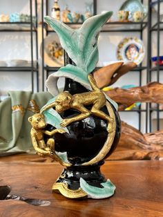 a black vase sitting on top of a wooden table