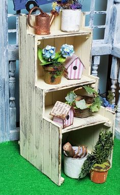 a shelf with potted plants and bird houses on it