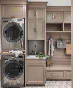 a washer and dryer in a room with wooden cupboards on the wall